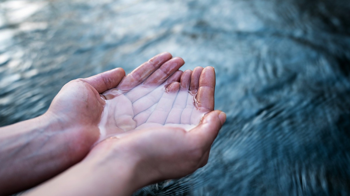 Eine geöffnete Hand schöpft klares, sauberes Wasser